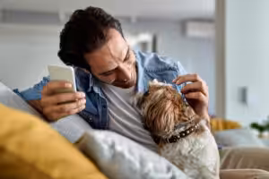 Homem brincando com um shih-tzu