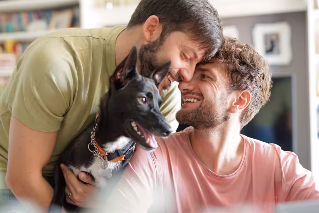 Close up of happy gay couple with dog adopted at animal shelter