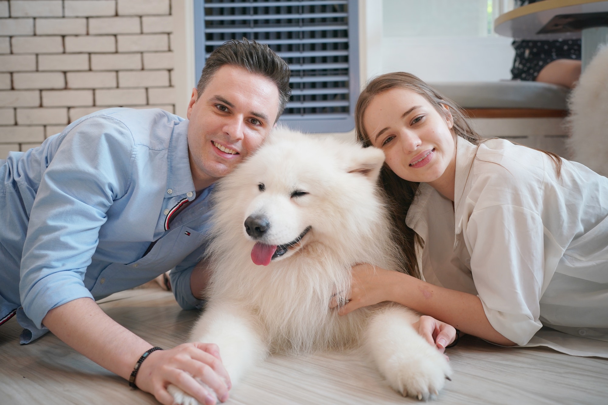 Couple and dog lying on floor.