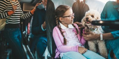 Menina andando de ônibus junto com cachorro