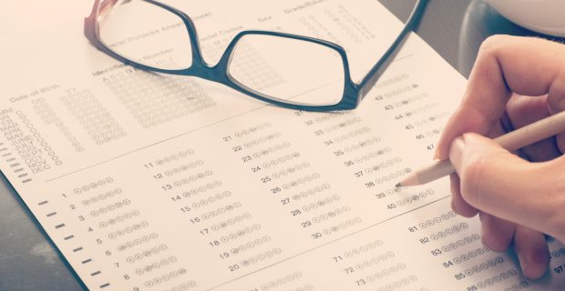 Close up of a man filling a standardized test form