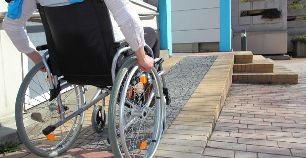 Frau im Rollstuhl auf Rollstuhlrampe