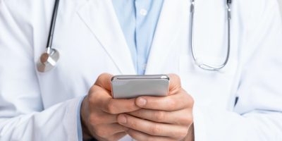 Close up of doctor holding smartphone in hands