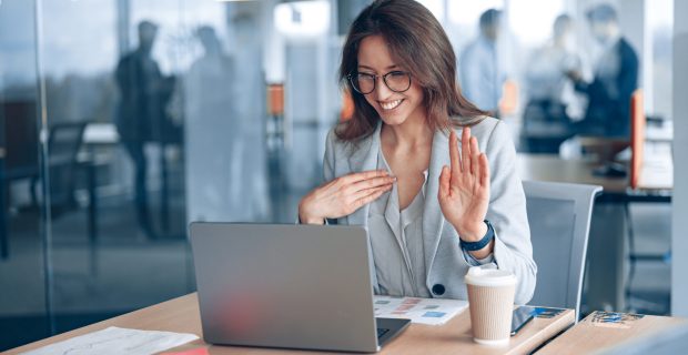 Confident deaf businesswoman communicating in video call with client at modern office