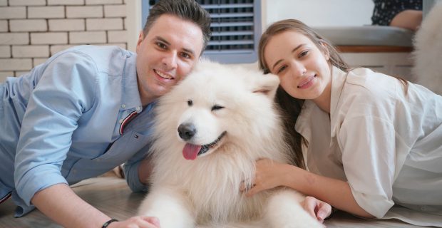 Couple and dog lying on floor.