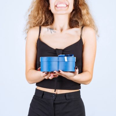 garota-loira-segurando-uma-caixa-de-presente-azul-e-parece-surpresa