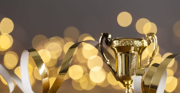 Gold award trophy against bright blurred lights