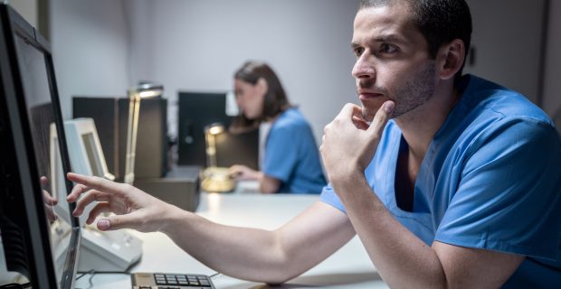 Health Care Workers In Hospital With Computer And Equipment