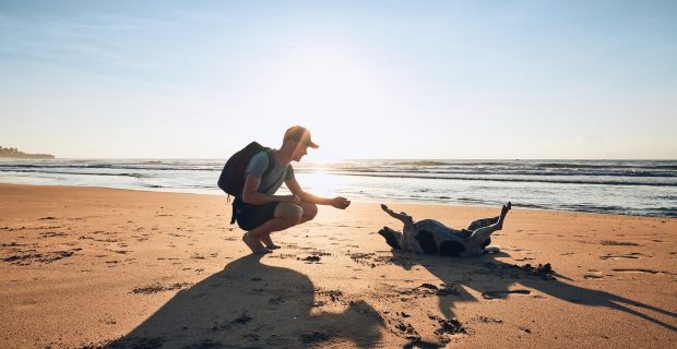 Young man with dog on beach