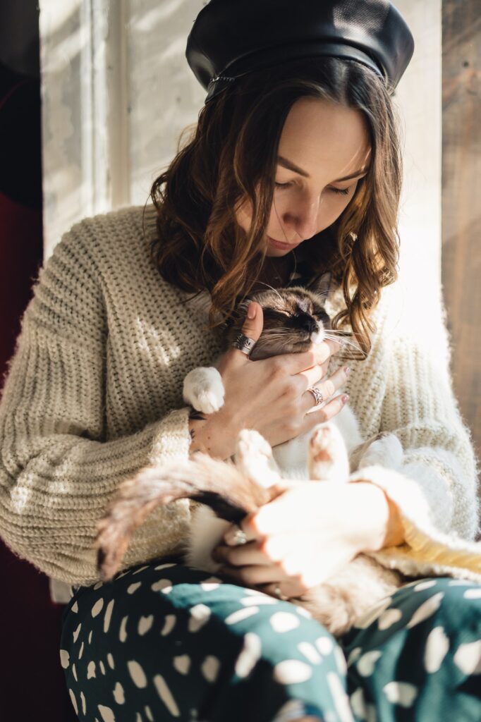 Pretty woman holding her cat paws stretching