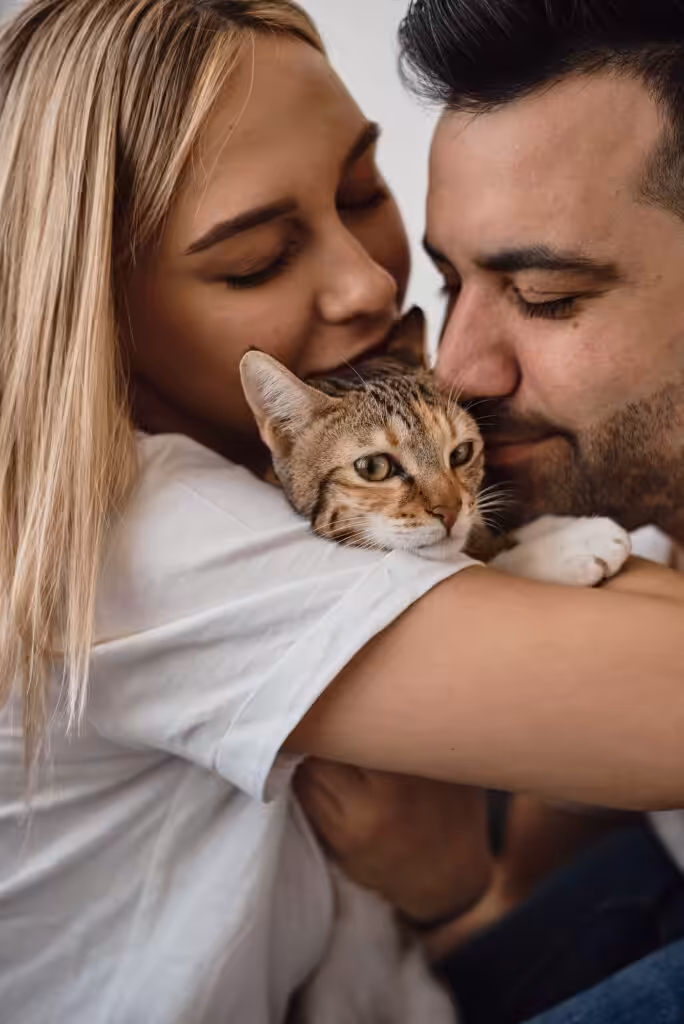 Young couple holding a small cat. Man and woman with their pet. Young family